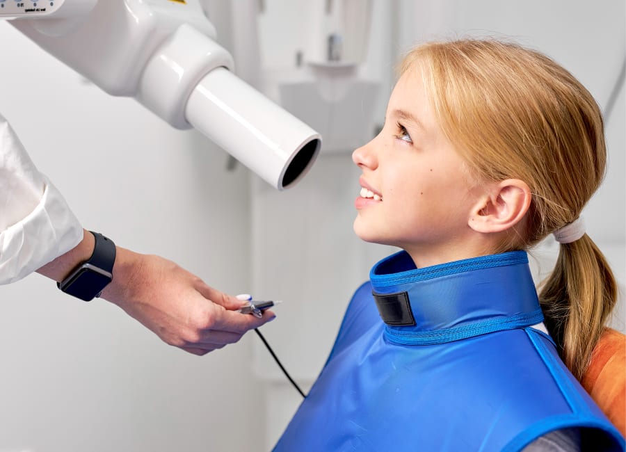 A dentist holds an X-ray up to the light for a better look.
